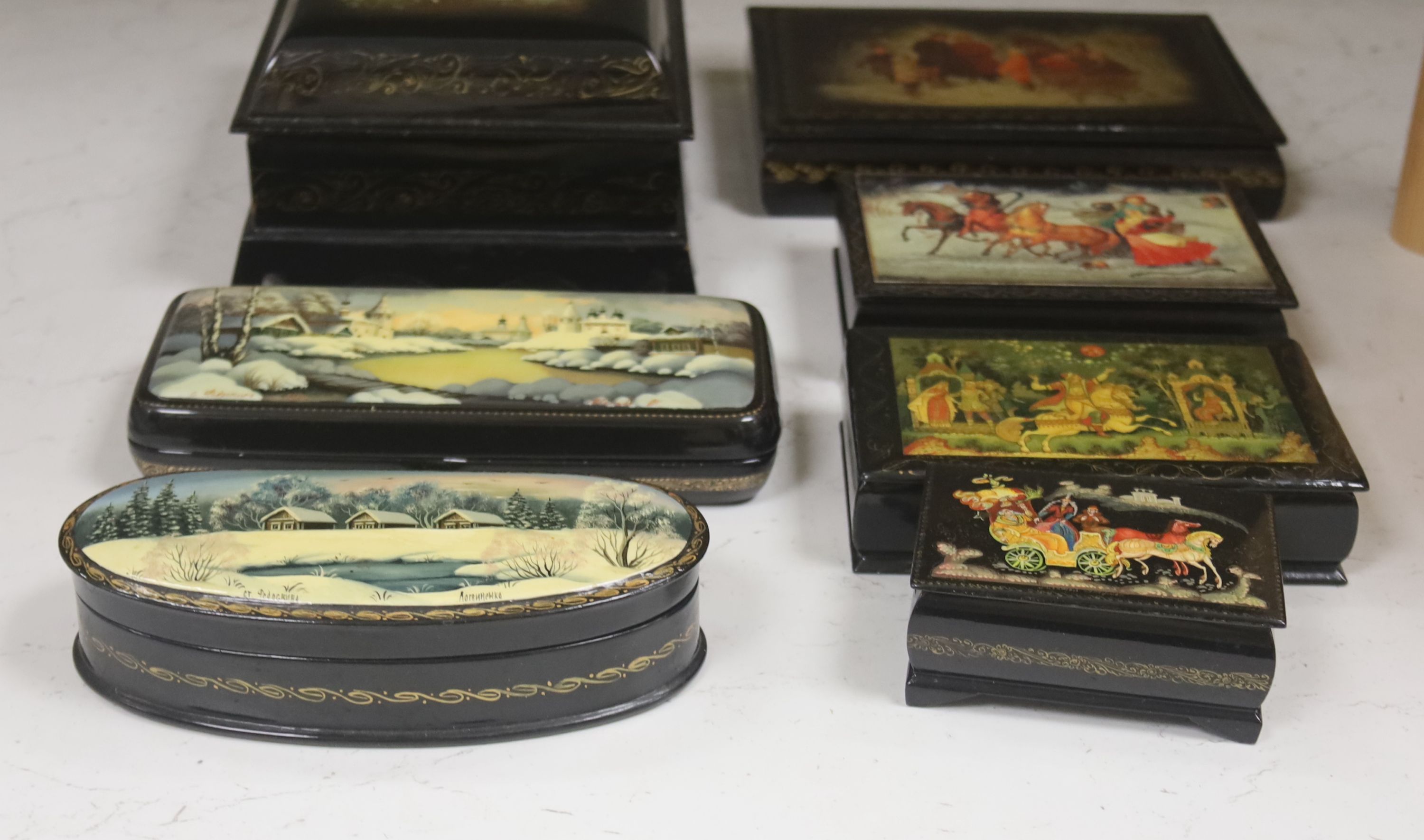 A collection of seven Russian painted lacquer boxes, largest raised on bracket base 15 x 20cm 9.5cm high
